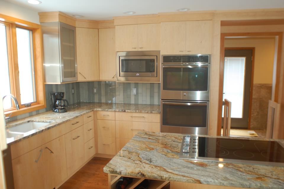 Large kitchen pantry photo with flat-panel cabinets and light wood cabinets