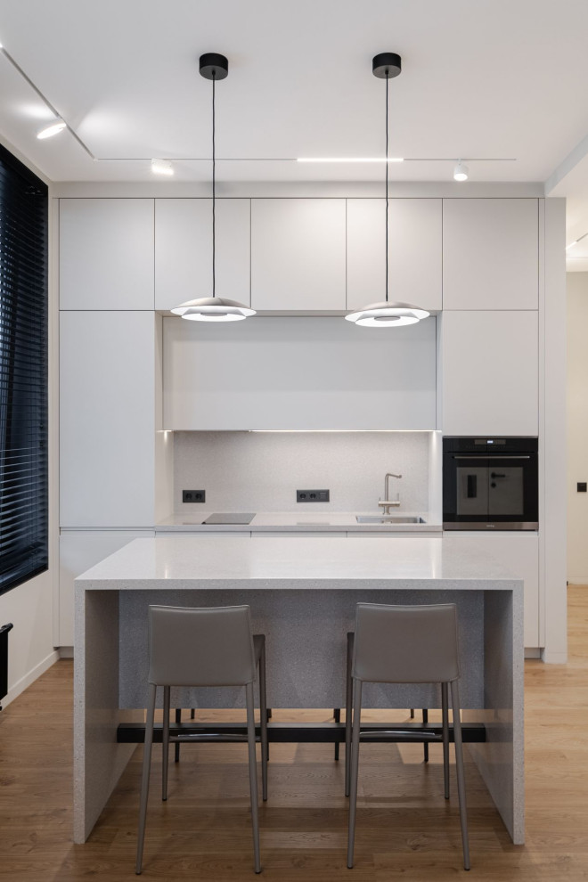 Idéer för att renovera ett mellanstort funkis grå grått kök, med en enkel diskho, släta luckor, grå skåp, bänkskiva i koppar, grått stänkskydd, integrerade vitvaror, mörkt trägolv, en köksö och brunt golv