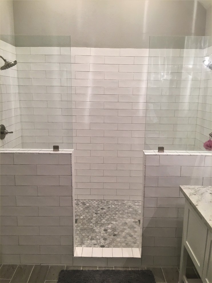 Photo of a large transitional master bathroom in Houston with shaker cabinets, white cabinets, a double shower, white tile, ceramic tile, grey walls, porcelain floors, an undermount sink, granite benchtops, grey floor and an open shower.