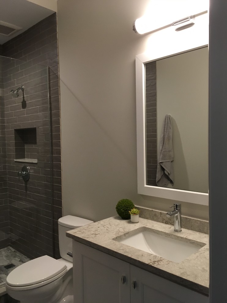 Mid-sized transitional 3/4 gray tile and ceramic tile porcelain tile and gray floor home design photo in Chicago with shaker cabinets, white cabinets, a two-piece toilet, beige walls, an undermount sink, quartz countertops and gray countertops
