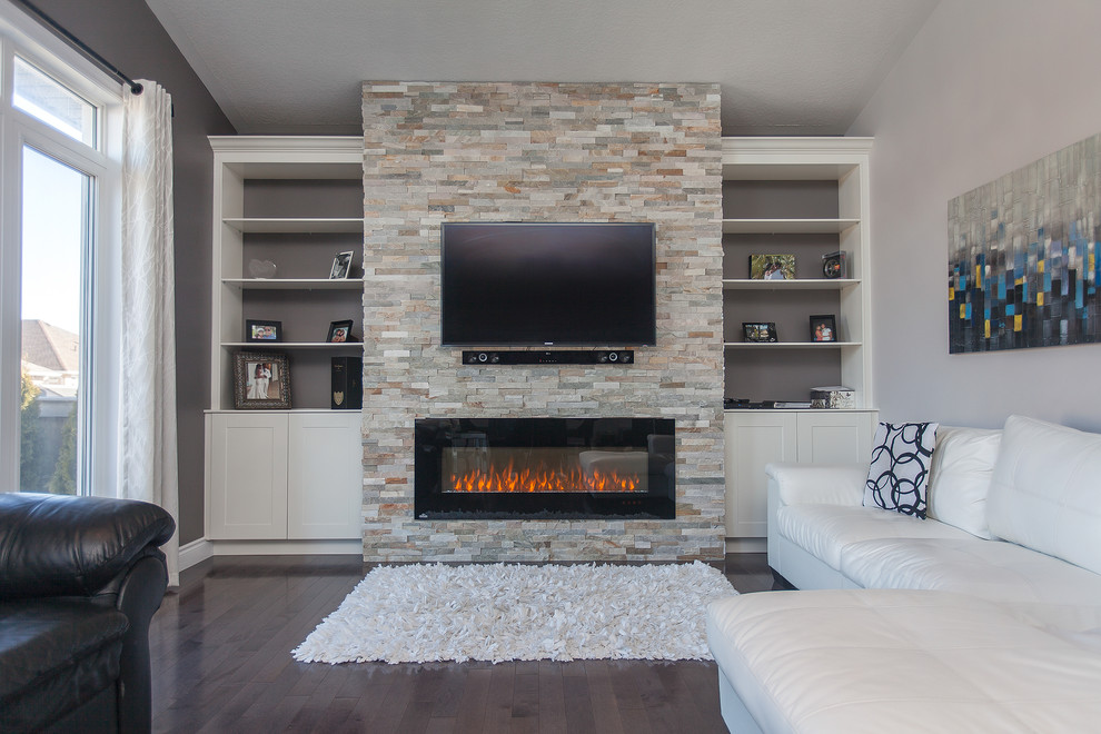 Large contemporary formal open concept living room in Toronto with grey walls, dark hardwood floors, a hanging fireplace, a stone fireplace surround and a built-in media wall.
