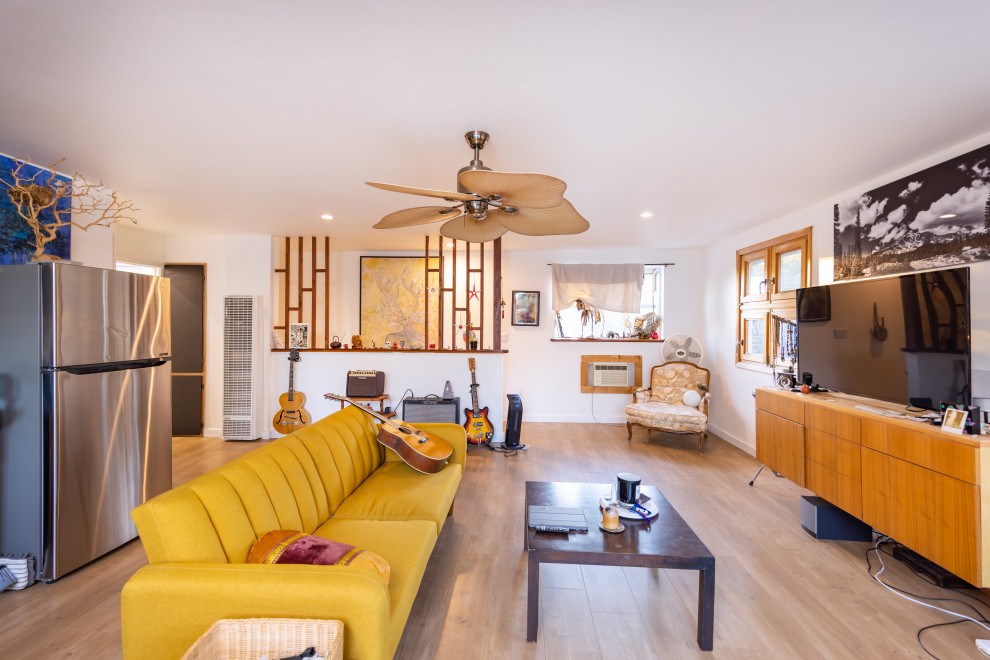 Esempio di un soggiorno design di medie dimensioni e stile loft con sala della musica, parquet chiaro, TV autoportante, pavimento marrone e pareti beige