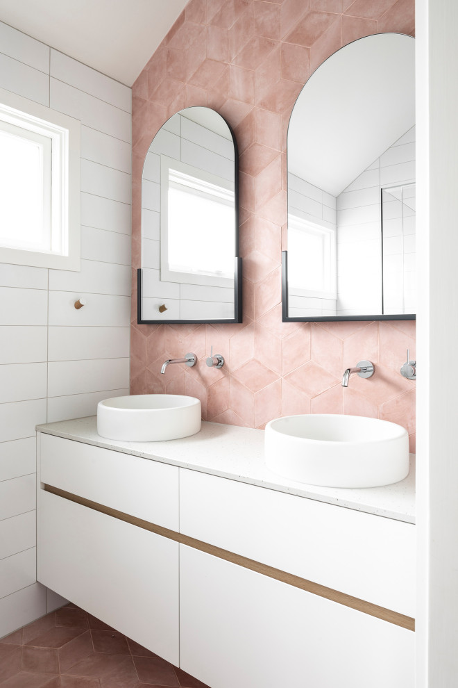 Стильный дизайн: ванная комната среднего размера в современном стиле с плоскими фасадами, белыми фасадами, душем в нише, унитазом-моноблоком, розовой плиткой, керамогранитной плиткой, белыми стенами, полом из керамогранита, душевой кабиной, настольной раковиной, столешницей из искусственного кварца, розовым полом, душем с распашными дверями, белой столешницей, тумбой под две раковины и встроенной тумбой - последний тренд