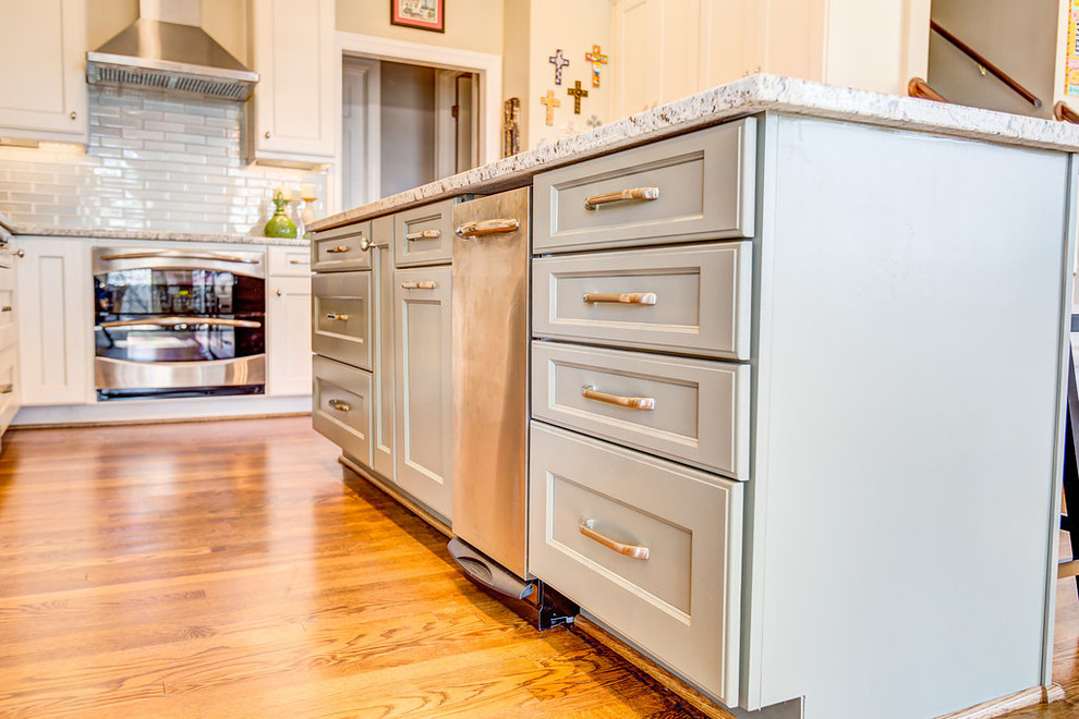 Inspiration for a mid-sized transitional l-shaped light wood floor open concept kitchen remodel in Birmingham with a single-bowl sink, flat-panel cabinets, white cabinets, granite countertops, green backsplash, glass tile backsplash, stainless steel appliances and an island