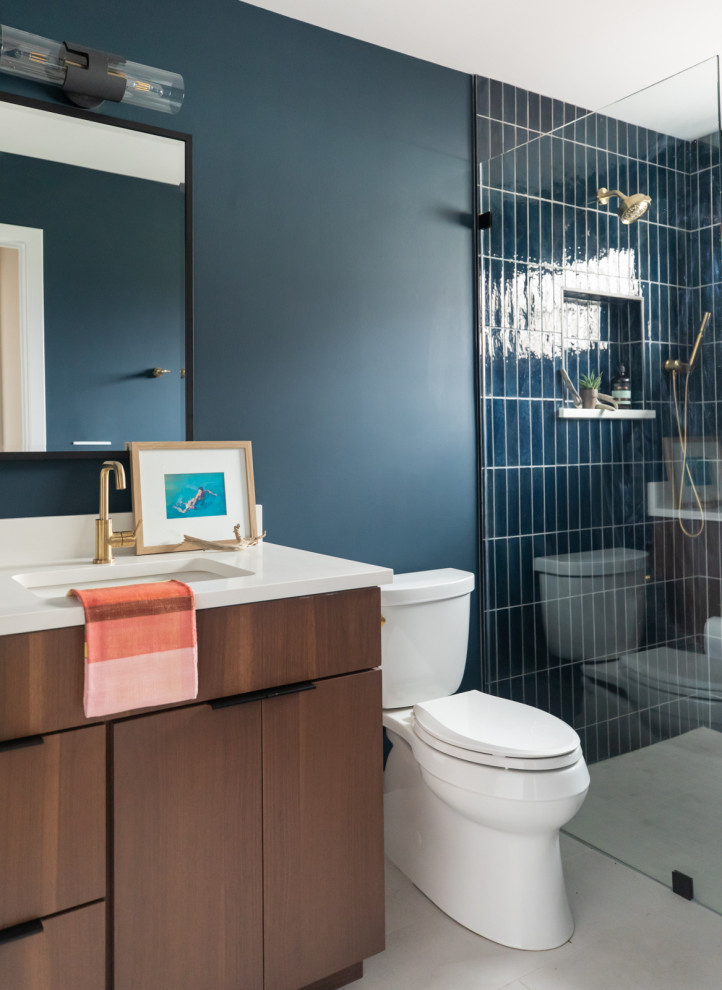 This is an example of a medium sized contemporary bathroom in Chicago with flat-panel cabinets, brown cabinets, a built-in shower, blue tiles, ceramic tiles, blue walls, ceramic flooring, a submerged sink, engineered stone worktops, white floors, a hinged door, white worktops, a wall niche, a single sink and a built in vanity unit.