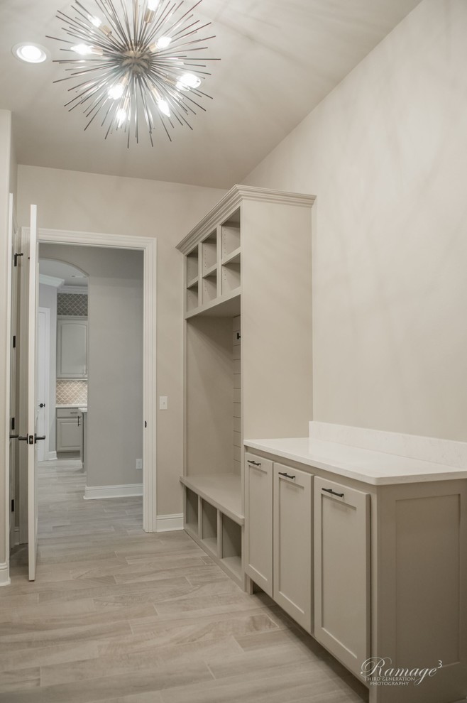 Photo of a mid-sized l-shaped dedicated laundry room in Other with recessed-panel cabinets, grey cabinets and quartzite benchtops.