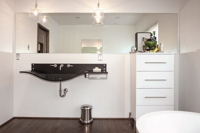 Large transitional master dark wood floor and brown floor freestanding bathtub photo in Denver with flat-panel cabinets, white cabinets, white walls and a wall-mount sink
