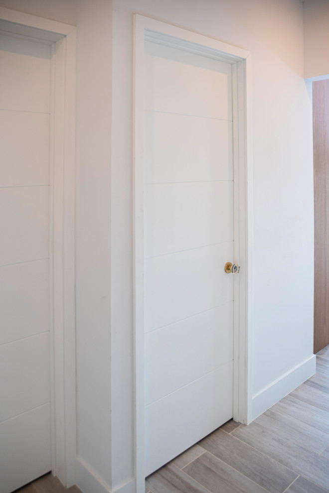 Modelo de recibidores y pasillos minimalistas de tamaño medio con paredes blancas, suelo de baldosas de cerámica y suelo marrón