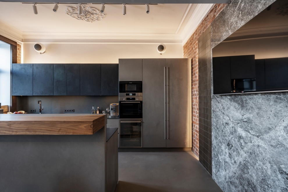 Idéer för att renovera ett stort industriellt svart linjärt svart kök och matrum, med en undermonterad diskho, släta luckor, svarta skåp, bänkskiva i kvarts, svart stänkskydd, integrerade vitvaror, betonggolv, en köksö och blått golv