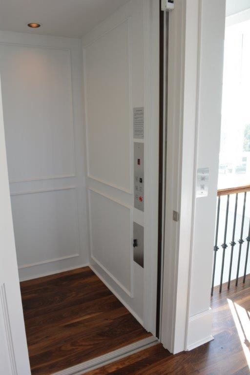 Inspiration for a mid-sized coastal medium tone wood floor and brown floor hallway remodel in Other with gray walls