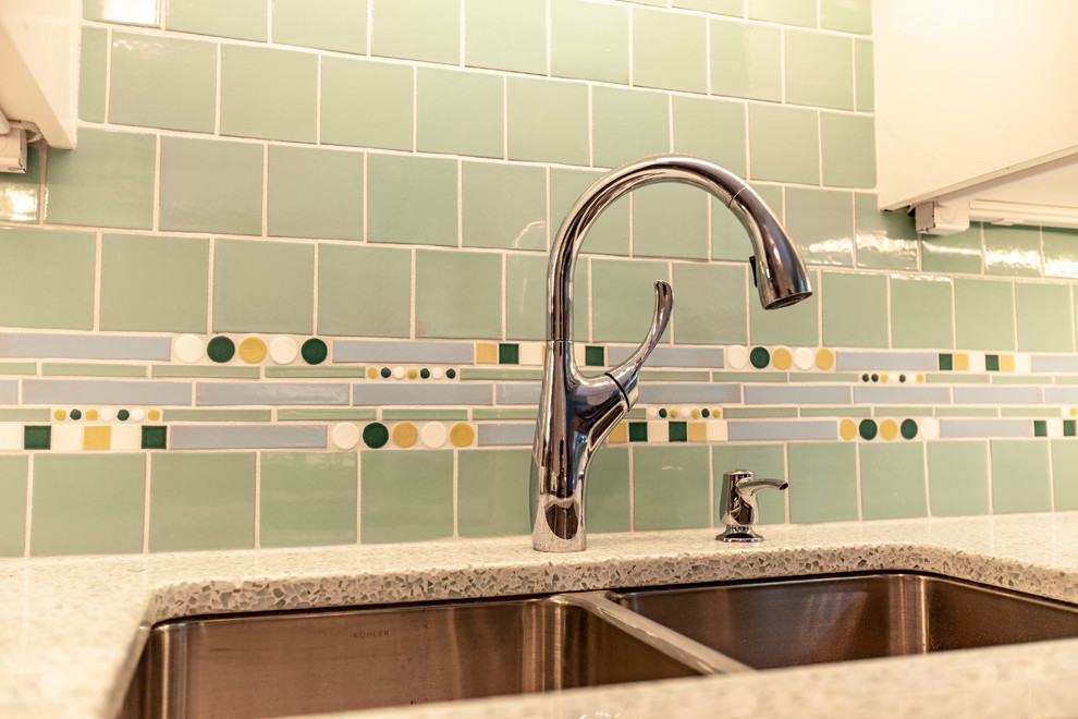 Midcentury separate kitchen in Minneapolis with an undermount sink, shaker cabinets, white cabinets, recycled glass benchtops, green splashback, mosaic tile splashback, stainless steel appliances, medium hardwood floors, no island, brown floor and white benchtop.
