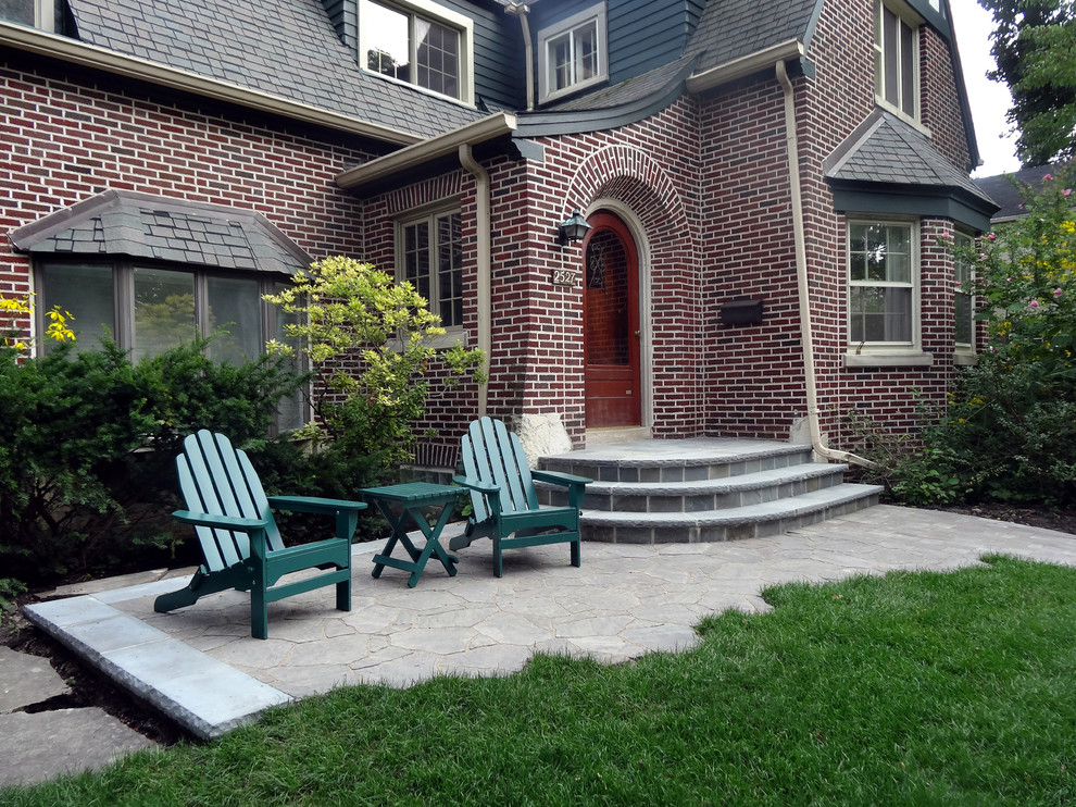 This is an example of a mid-sized traditional front yard garden in Chicago with concrete pavers.