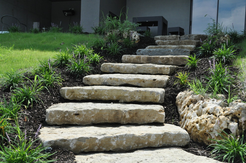 This is an example of a small contemporary partial sun hillside stone landscaping in Kansas City.