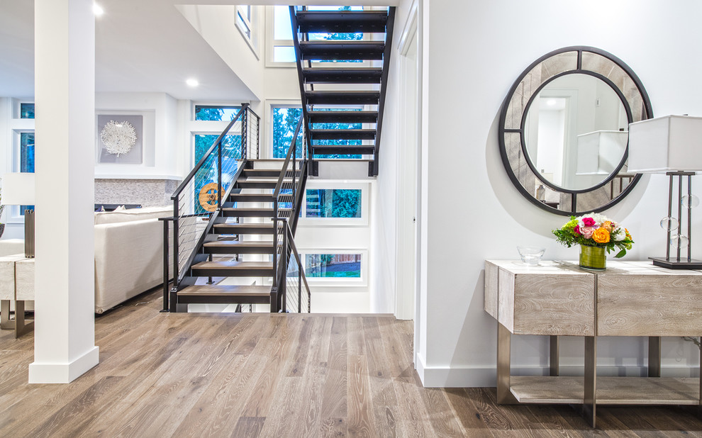 Photo of a mid-sized transitional wood floating staircase in Seattle with open risers and cable railing.