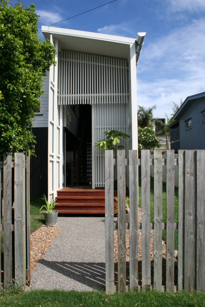 Mittelgroßer Moderner Eingang mit weißer Wandfarbe, braunem Holzboden, Schiebetür, weißer Haustür, braunem Boden und Holzwänden in Brisbane