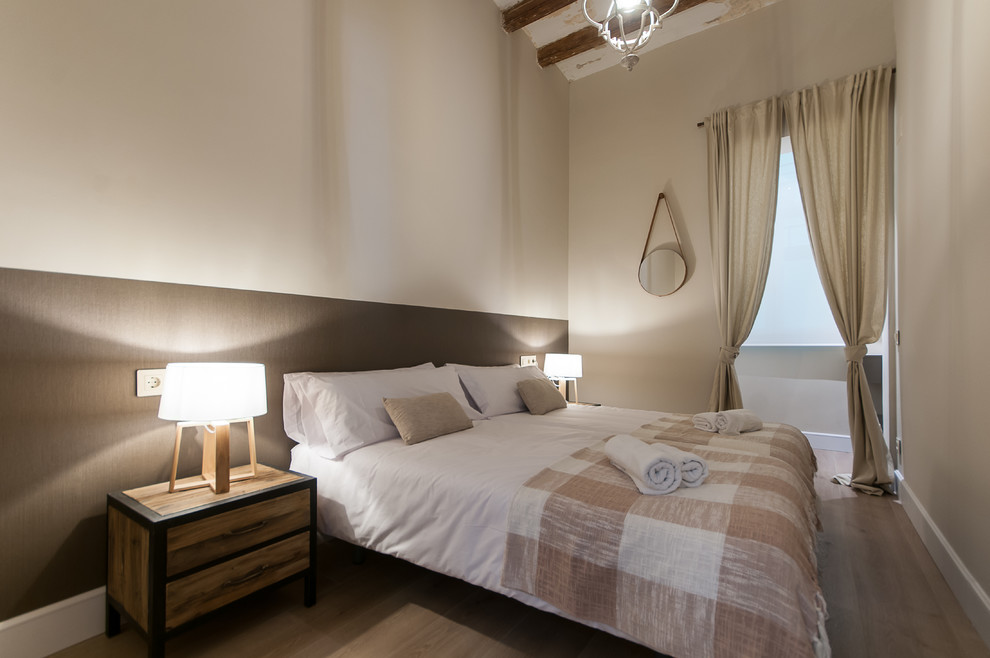 Mid-sized scandinavian master bedroom in Barcelona with beige walls, medium hardwood floors and no fireplace.