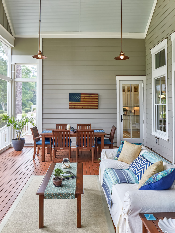 Design ideas for a large beach style backyard screened-in verandah in Charleston with a roof extension.