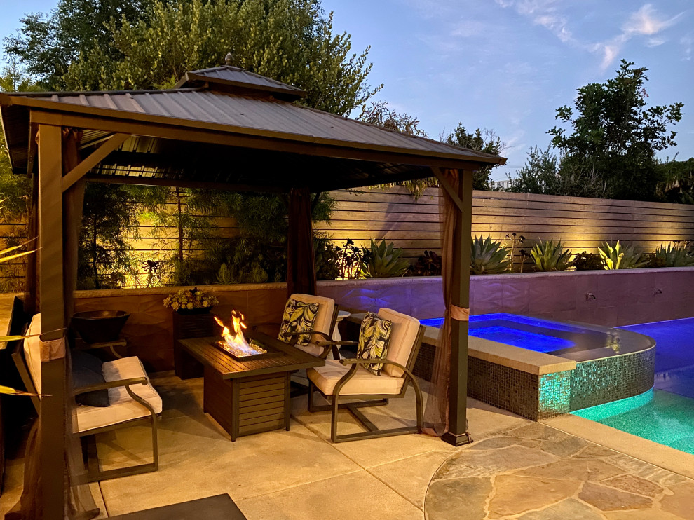 Стильный дизайн: большой прямоугольный бассейн на заднем дворе в современном стиле с покрытием из каменной брусчатки - последний тренд