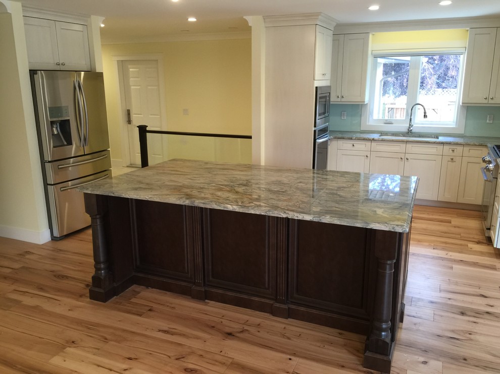 Kitchen - mid-sized eclectic light wood floor kitchen idea in Calgary with shaker cabinets, white cabinets, quartzite countertops, stainless steel appliances, an island and glass sheet backsplash