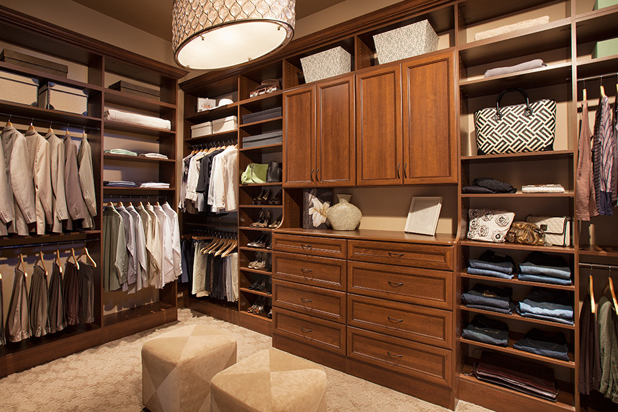This is an example of a large traditional gender-neutral walk-in wardrobe in Other with medium wood cabinets.