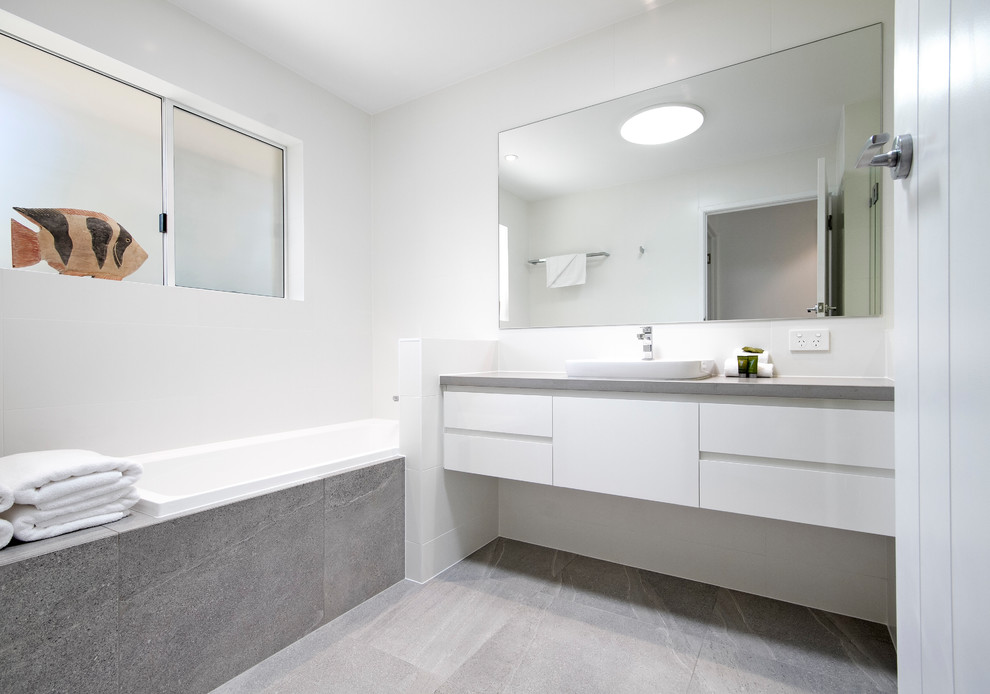 Design ideas for a mid-sized beach style bathroom in Sunshine Coast with white cabinets, a drop-in tub, a double shower, white tile, porcelain tile, white walls, porcelain floors, a drop-in sink, engineered quartz benchtops, grey floor and a hinged shower door.