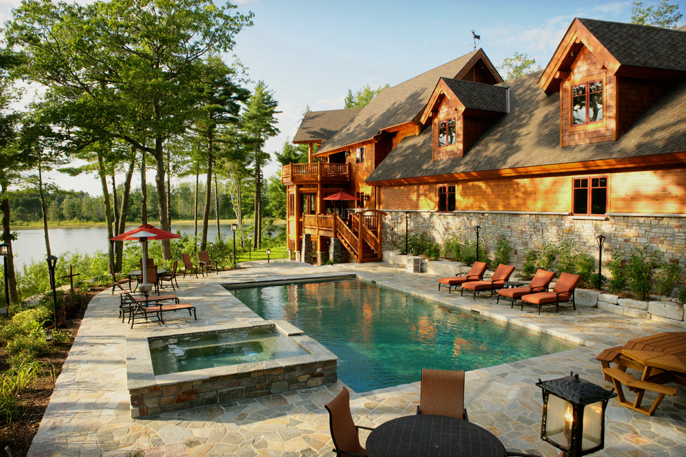 Inspiration for a rustic backyard stone and rectangular hot tub remodel