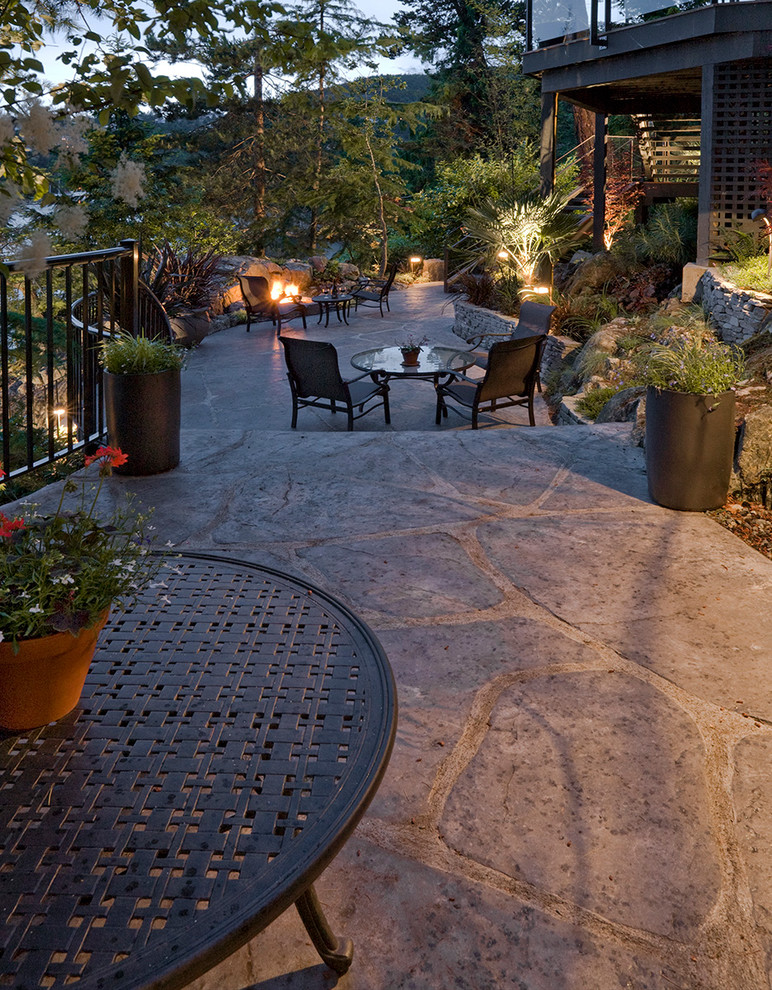 Design ideas for a mid-sized modern sloped partial sun garden for summer in Vancouver with a fire feature and natural stone pavers.
