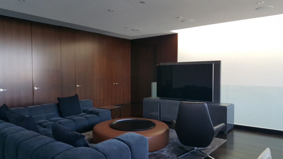 Immagine di un grande soggiorno minimalista aperto con sala giochi, pareti marroni, parquet scuro, TV autoportante, pavimento marrone e pannellatura