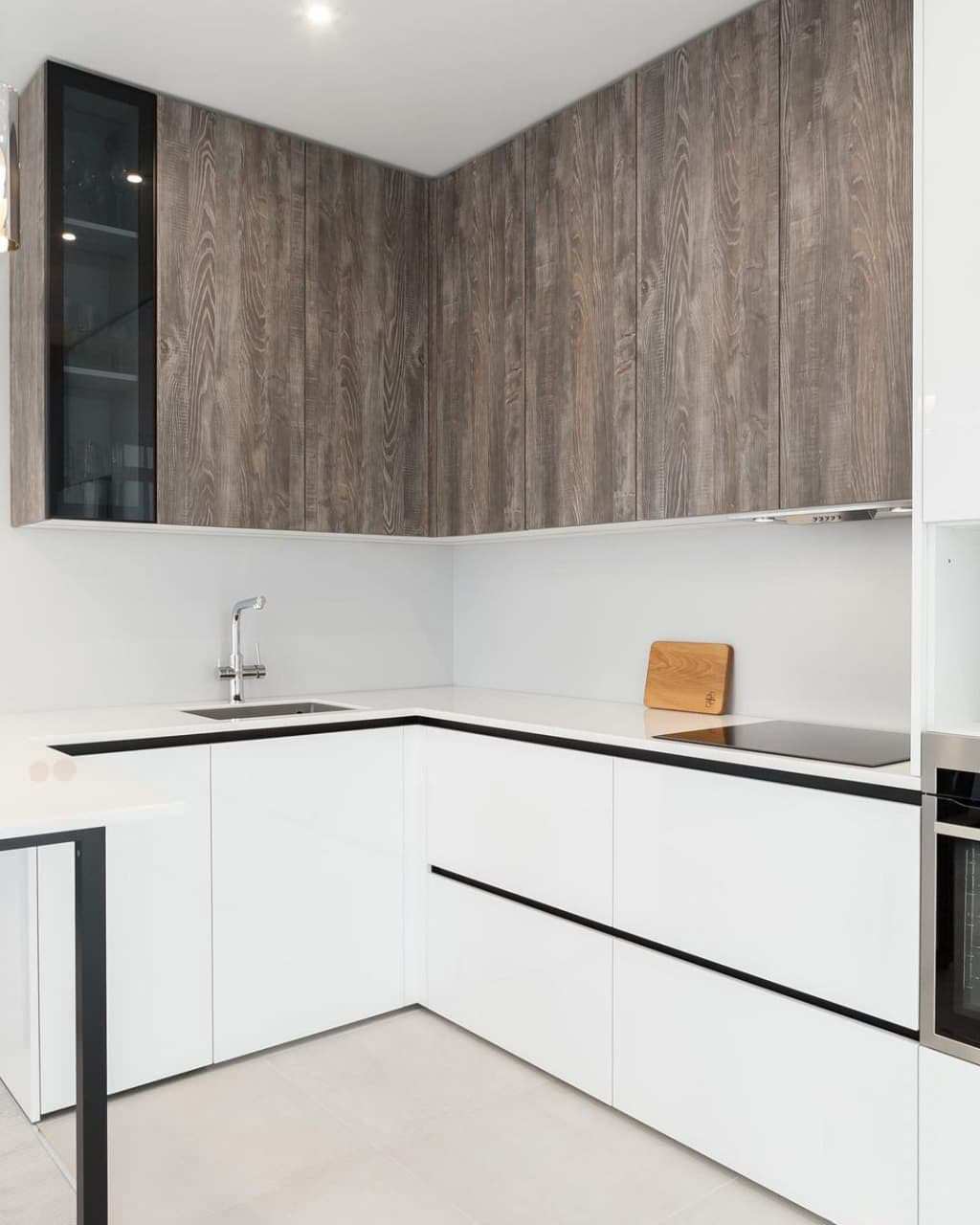 Современная серо-белая кухня в высокими шкафами и барной стойкой