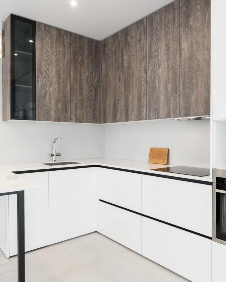 Современная серо-белая кухня в высокими шкафами и барной стойкой