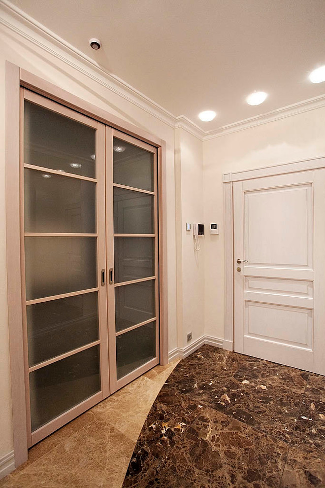 На фото: коридор среднего размера с мраморным полом, коричневым полом и белыми стенами