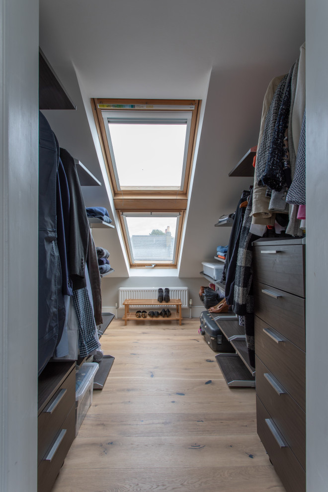 Design ideas for a small contemporary storage and wardrobe in London with light hardwood floors.