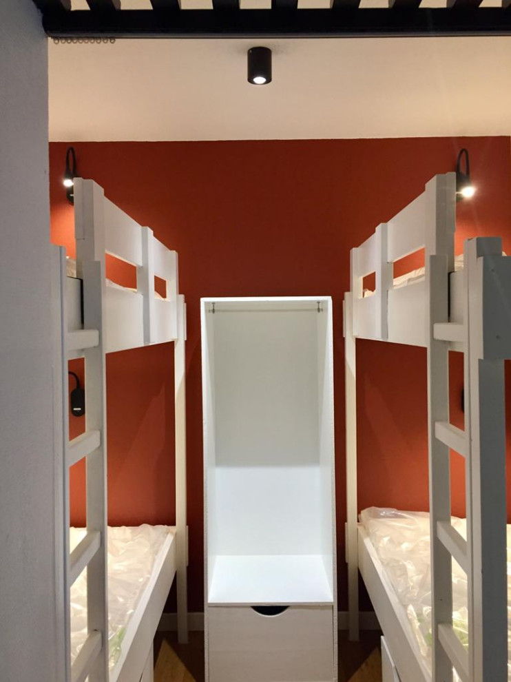 Cette photo montre une petite chambre d'enfant montagne avec un mur orange et parquet clair.
