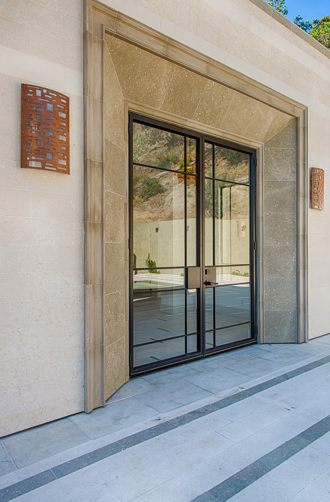 Large transitional concrete floor and gray floor front door photo in Los Angeles with a glass front door