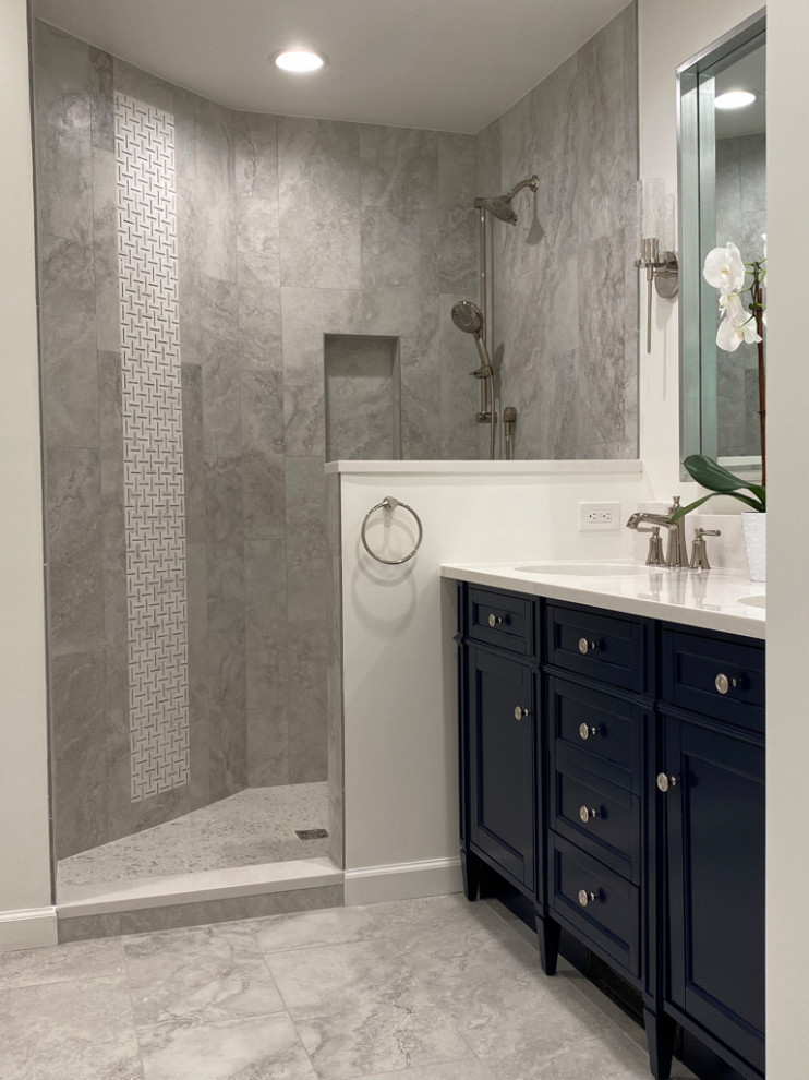 Inspiration for a mid-sized eclectic bathroom in Bridgeport with shaker cabinets, blue cabinets, a corner shower, marble, white walls, porcelain floors, an undermount sink, engineered quartz benchtops, grey floor, white benchtops and a double vanity.
