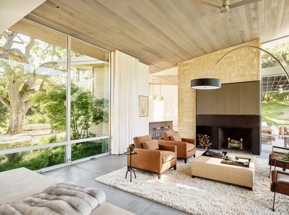 This is an example of a contemporary formal living room in San Francisco with concrete floors and a standard fireplace.