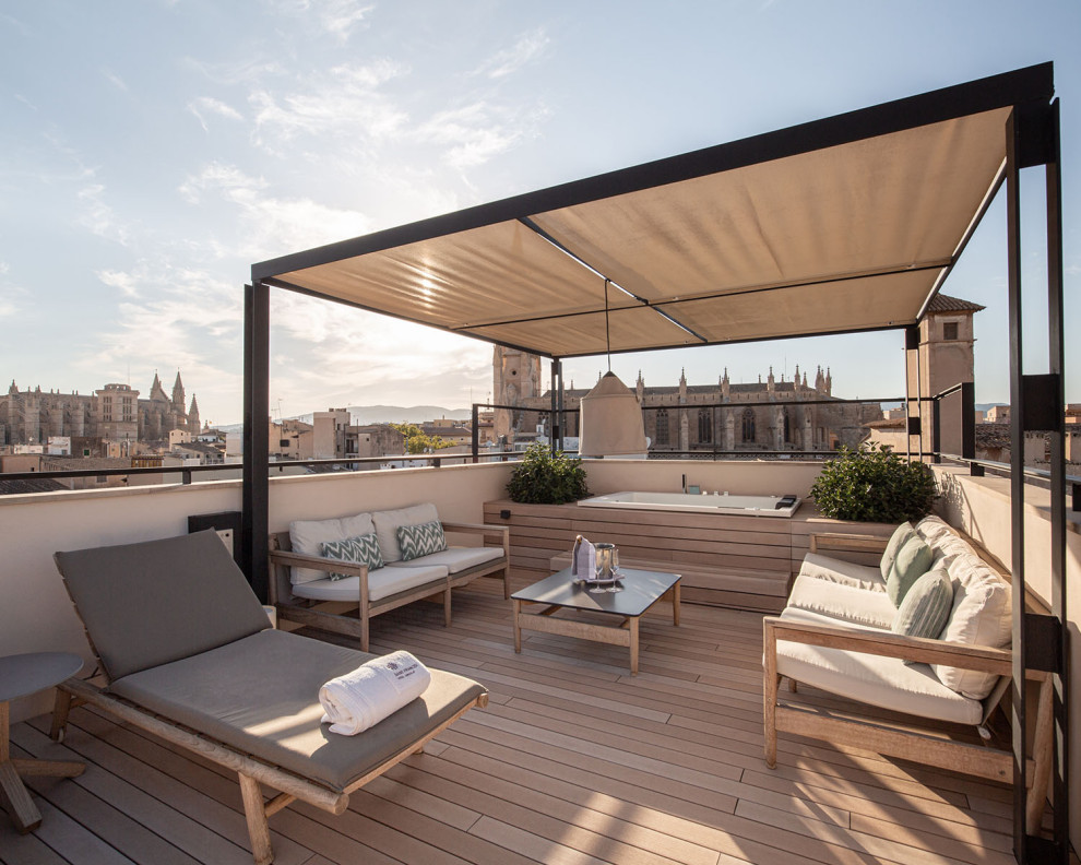 This is an example of a mid-sized rooftop and rooftop deck in Frankfurt with an outdoor shower, an awning and mixed railing.