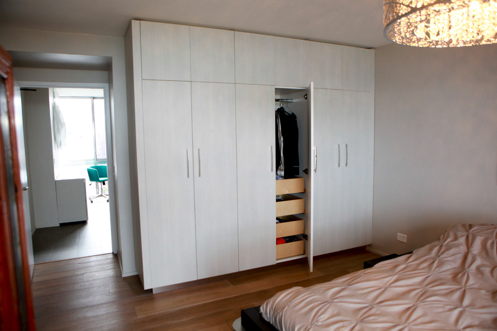 Small contemporary gender-neutral storage and wardrobe in Chicago with flat-panel cabinets, grey cabinets, vinyl floors and brown floor.