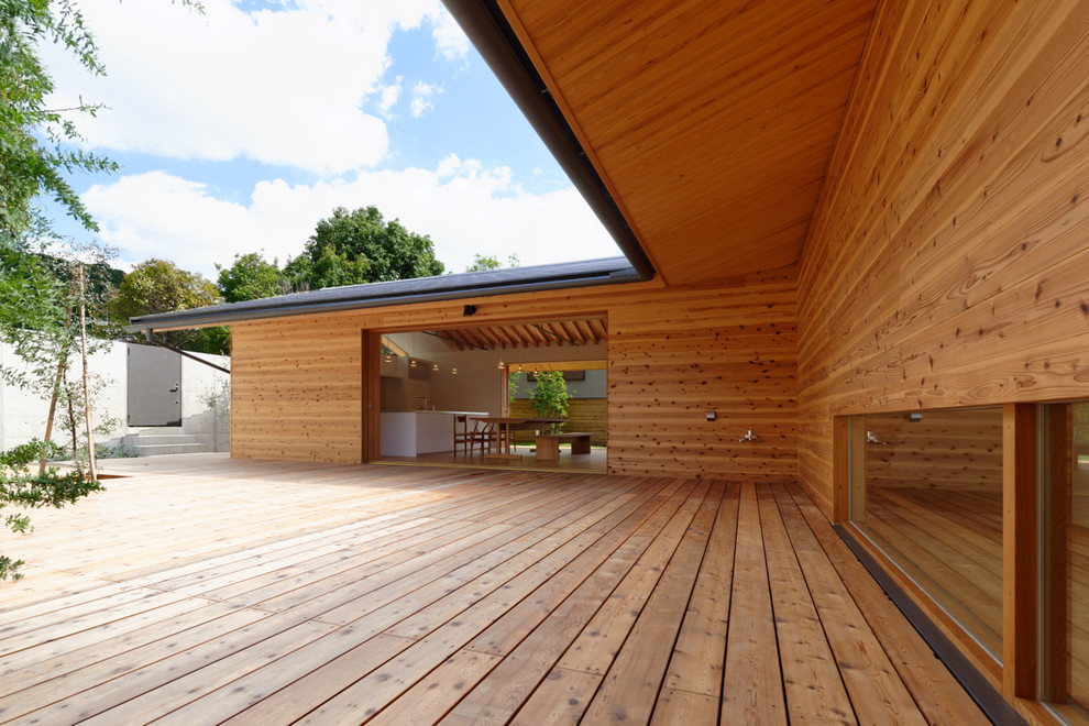 Inspiration for a modern courtyard deck in Kyoto with a roof extension.