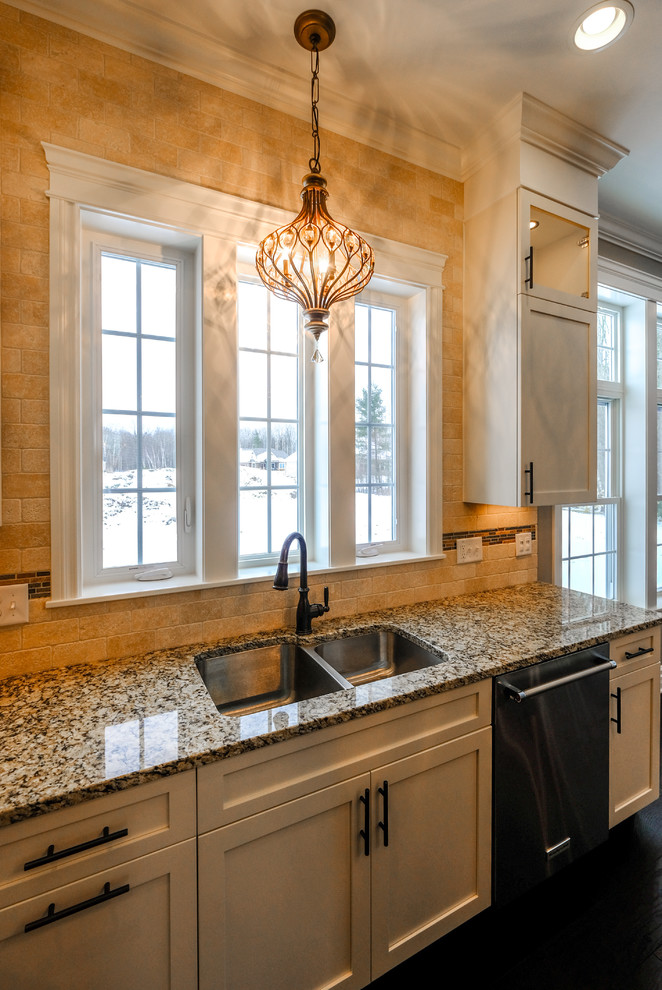 Large transitional u-shaped dark wood floor and brown floor eat-in kitchen photo with an undermount sink, recessed-panel cabinets, white cabinets, granite countertops, beige backsplash, stainless steel appliances and an island