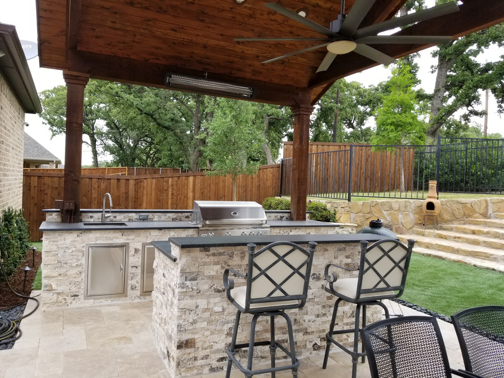 This is an example of a large traditional backyard patio in Dallas with an outdoor kitchen, natural stone pavers and a gazebo/cabana.