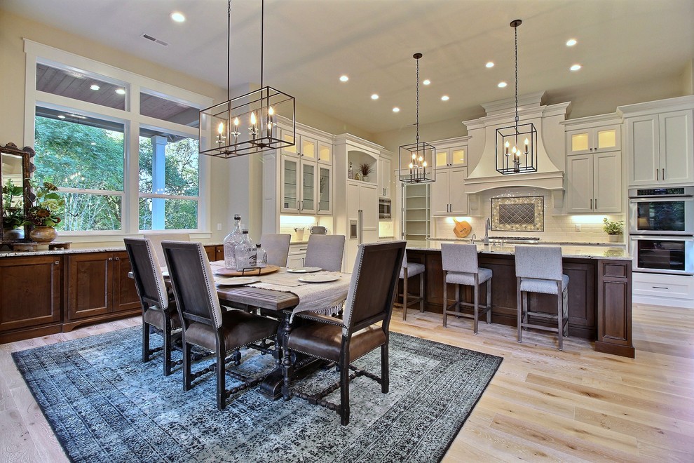 Inspiration for an expansive traditional open plan dining in Portland with beige walls, light hardwood floors, a standard fireplace, a stone fireplace surround and beige floor.