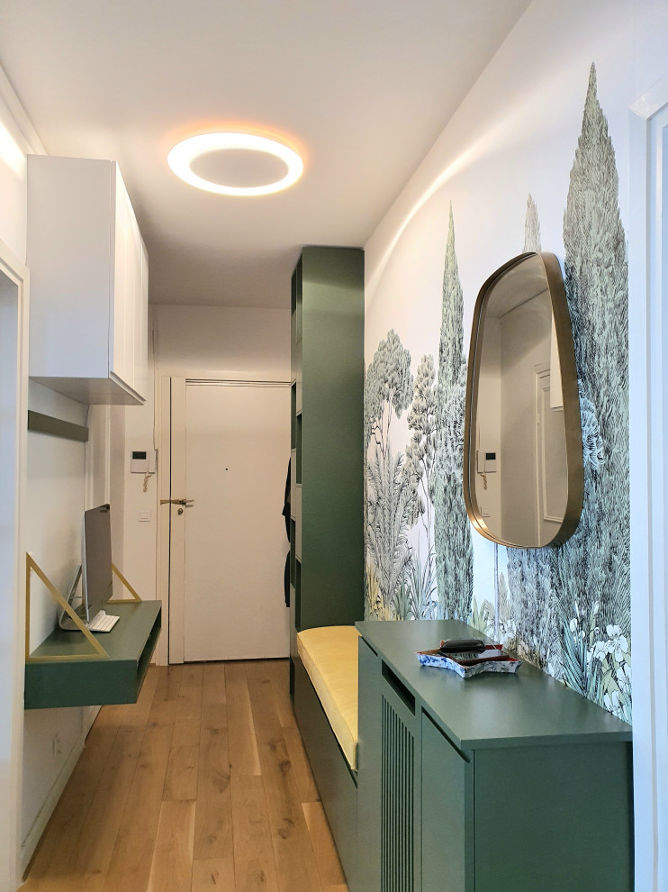 This is an example of a mid-sized contemporary entry hall in Paris with green walls, light hardwood floors, a single front door, a white front door, beige floor and wallpaper.