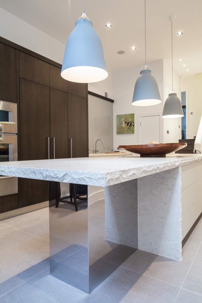 Design ideas for a large contemporary eat-in kitchen in London with an integrated sink, dark wood cabinets, limestone benchtops, white splashback, glass sheet splashback, stainless steel appliances and with island.