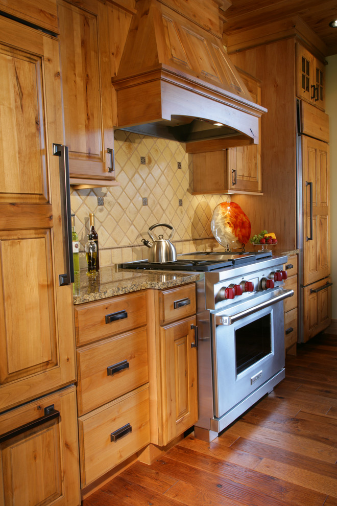 Large mountain style u-shaped medium tone wood floor and brown floor eat-in kitchen photo with an undermount sink, raised-panel cabinets, dark wood cabinets, granite countertops, white backsplash, ceramic backsplash, paneled appliances and two islands