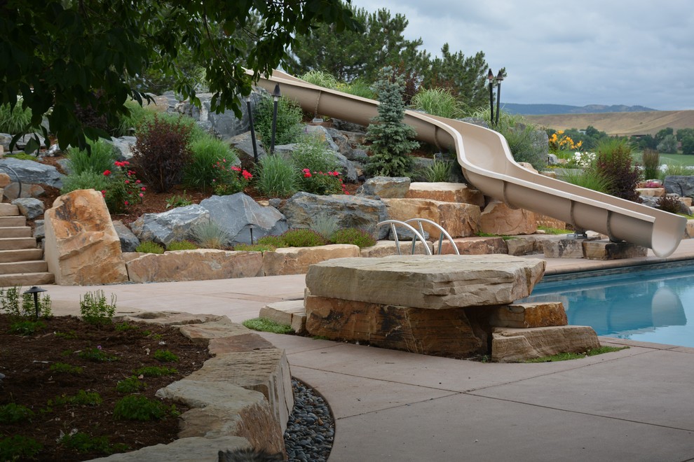 Photo of a large contemporary backyard rectangular lap pool in Denver with a water slide and concrete slab.