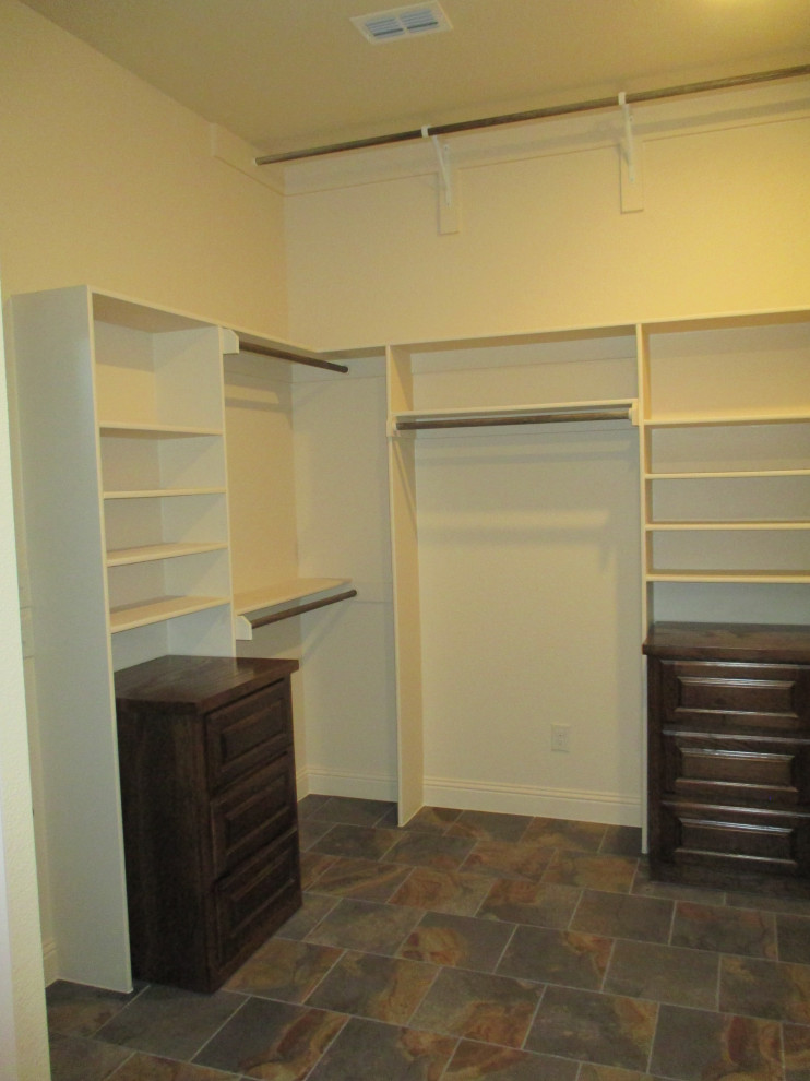 Photo of a large country gender-neutral walk-in wardrobe in Dallas with raised-panel cabinets, dark wood cabinets, slate floors and multi-coloured floor.