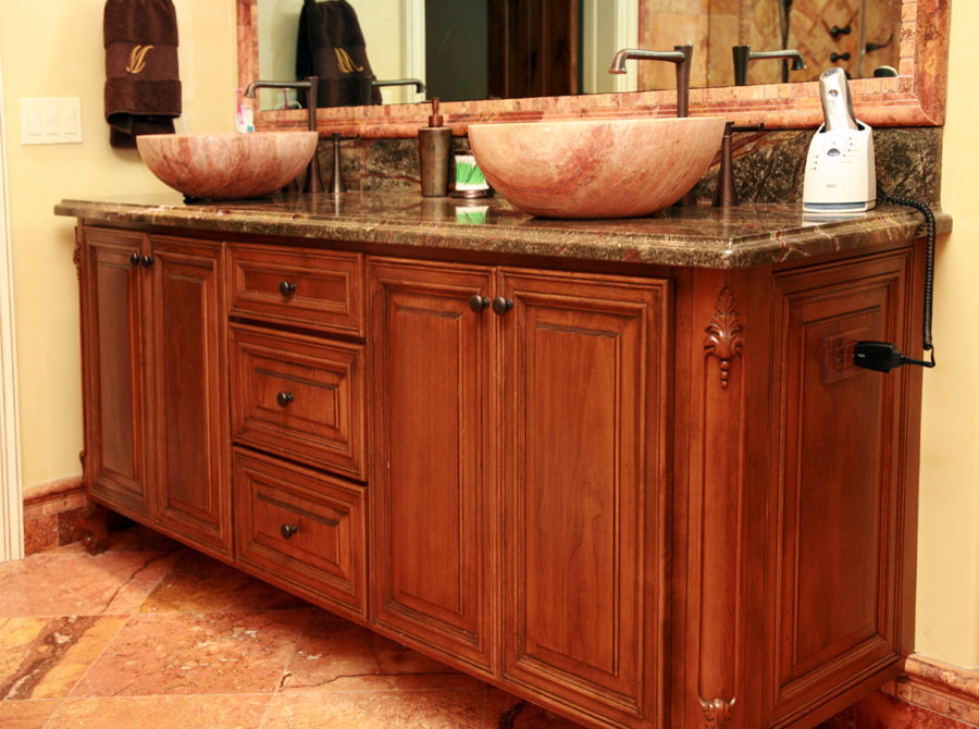 Example of a mid-sized transitional master ceramic tile corner shower design with raised-panel cabinets, medium tone wood cabinets, an undermount tub, beige walls, a vessel sink and granite countertops
