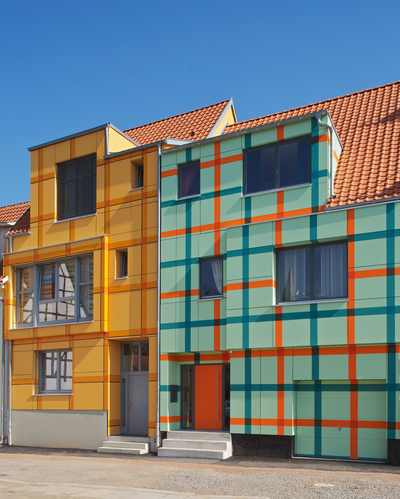 This is an example of a mid-sized contemporary three-storey orange exterior in Bremen with a gable roof.