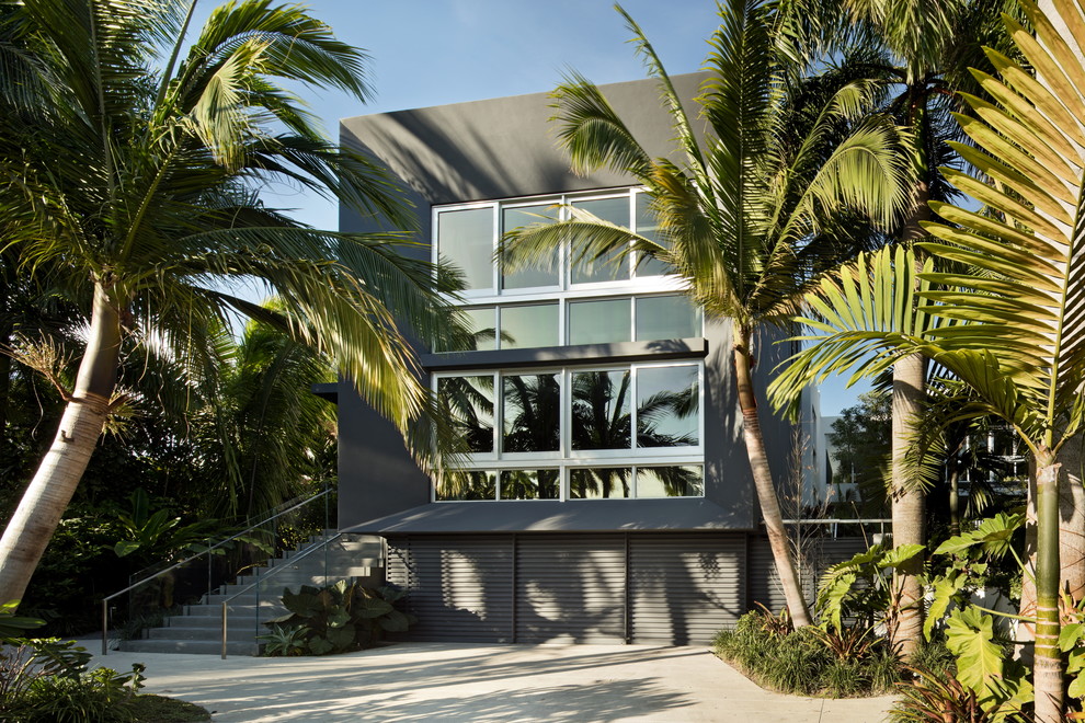 Photo of a large modern two-storey stucco grey house exterior in Miami with a flat roof.
